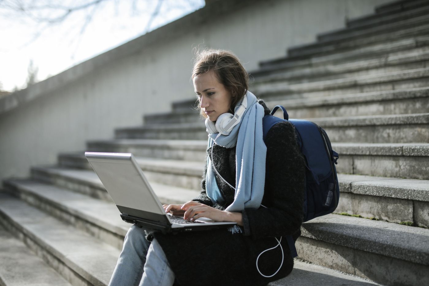 A student working on a laptop outdoors